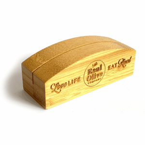 POS bamboo block with The Real Olive Company branding on it and the words 'Love Life Eat Real.