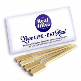 Pack of meze skewers with 4 skewers laying in front on it.