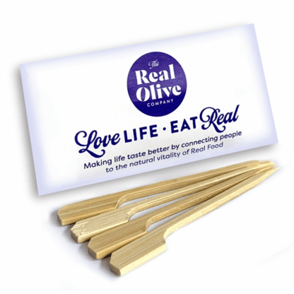 Pack of meze skewers with 4 skewers laying in front on it.