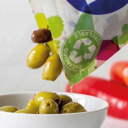 Olives being poured out of a The Real Olive Company 1kg resealable foodservice pouch into a bowl.